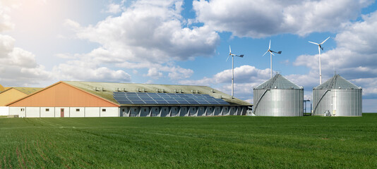 Fototapeta na wymiar Modern dairy farm using renewable energy, solar panels and wind turbines 