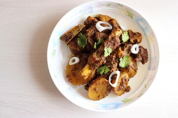 Mutton ghee roast. Goat meat fry with potatoes, also known as Mutton Batata bhujing. Spicy non-vegetarian lamb fry dish. Mutton curry or mutton fry. copy space.