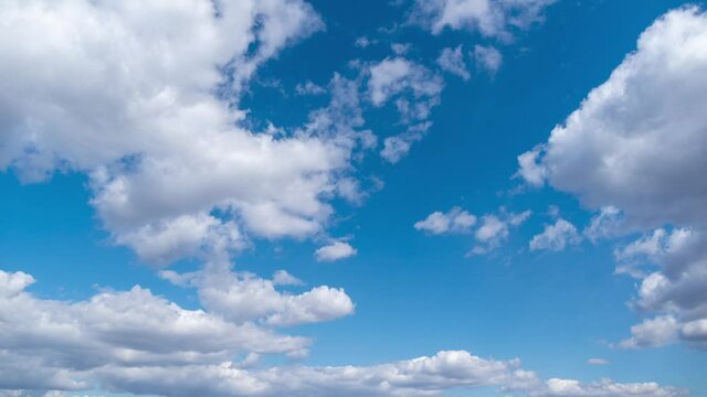 4k time lapse stock video footage of beautiful sunny clear blue sky with many moving along fluffy white clouds of different sizes