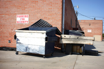 Trash dumped behind building in urban alley 