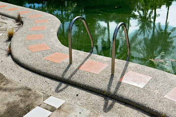Close-up scene of an unmaintained dirty swimming pool, algae, leafs and grass visible; Hotel closures on Boracay Island during the covid pandemic