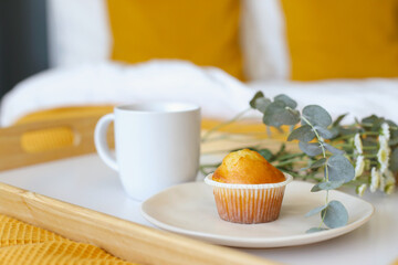Wooden tray with a white cup of black coffee on orange linen. Good morning concept