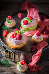 Pink muffin with cream and fruits. Vanilla cupcake with fruit.