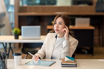 Business woman sit and think about work plans using a tablet at the office.