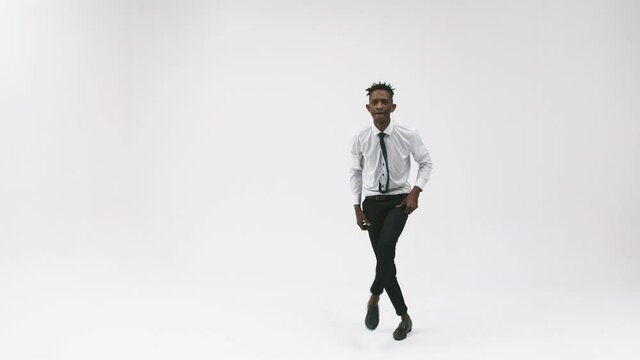 Black serious man in an office suit dancing breakdancing in the studio. Black office man dancing breakdance on a white background.
