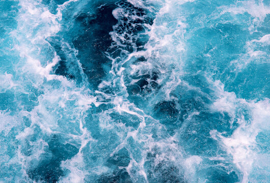 Wavy sea foam after motor boat. Seascape perspective view. Maritime transportation on cruise ship or motor boat. White wave on oceanic surface. Deep blue water of open sea . Nautical background