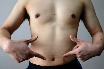 Naklejka premium ダイエットに成功してお腹を指差す男性