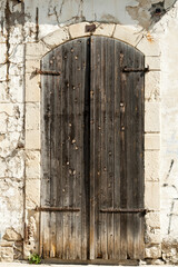 Old wooden front door in stone wall 