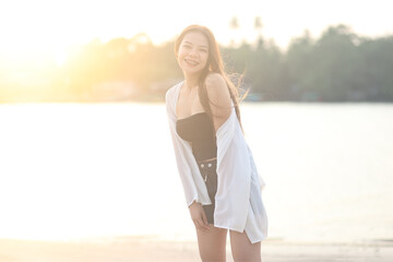 Asian girl walking on the beach with sunset in the summer. Beautiful girl travel in the summer at krabi province,Thailand.