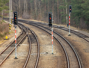 Empty tracks with red traffic lights before the turn.