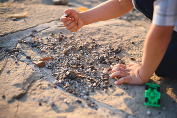 boy playing with stones on ground