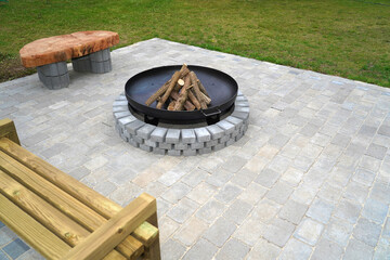 Iron fire pit and firewoods ready to burn on fireplace in a garden .