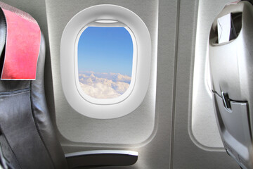  Airplane seats, blue sky and clouds appear from the window.  Conceptual image.