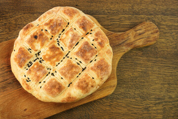 Traditional Turkish ramadan pita bread on a wooden kitchen board.