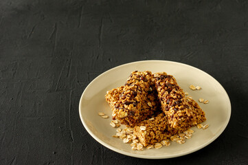 homemade granola energy bars with almond and raisins on black background. Healthy food