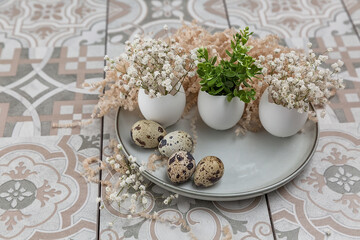 Easter composition. Easter eggs on a plate. A small bouquet in an egg. The minimal concept of Easter. An Easter card with a place for the text.