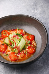 ceviche with srawberry and cucumber closeup on light concrete table backdrop