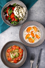 various salad top view. ceviche, buratta and persimmon with pine nuts. different fresh salads