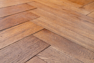 Low angle photo of orange brown aged hardwood oak tile floor of herringbone flooring. Hundred years...