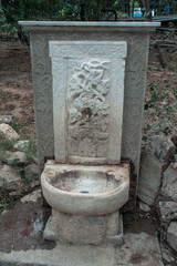 Vertical shot of an old ancient stone-made fountain with a faucet in Athens, Greece