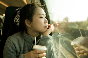 train travel getaway - lifestyle portrait of young happy and beautiful Asian Japanese woman traveling on railway looking through window  drinking coffee