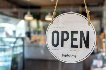 Open. coffee cafe shop text on vintage sign board hanging on glass door in modern cafe shop reopen after coronavirus quarantine is over in restaurant ready to service, small business owner concept - obrazy, fototapety, plakaty