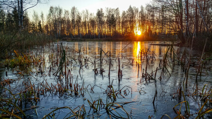 Sunset reflected in a frozen lake in late autumn