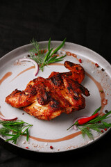 chicken tobacco closeup on ceramic plate with green and chilli pepper