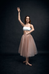 Naklejka premium Young girl in white top and peach skirt dancing