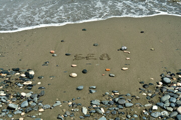Fototapeta na wymiar Beach with word Sea written on sand