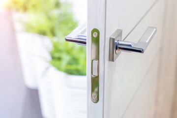 White open interior door with chrome handle. Contemporary door handle. Selected focus