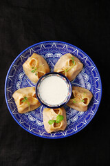 Stuffed dumplings, manti of dough and minced, close up Traditional chinese dim sum dumplings on dark background