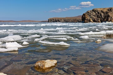 Spring Baikal Lake. Beautiful landscape with white ice floes melting on the coast of Olkhon Island at a sunny day. Ice drift in the Small Sea Strait. Natural background. Change of seasons