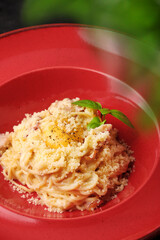 carbonara pasta with basil leaf and egg closeup