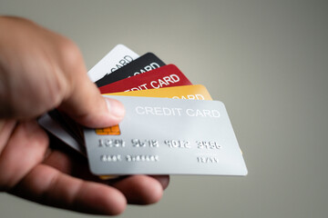 Multiple colors credit card in hand use paying for shopping in store and online, payment via bank and financial concept 
