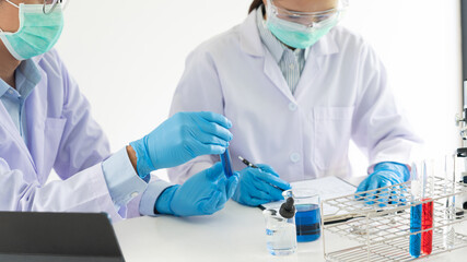 Team of Medical Research Scientists or researcher in lab coat testing their experimental in Modern...