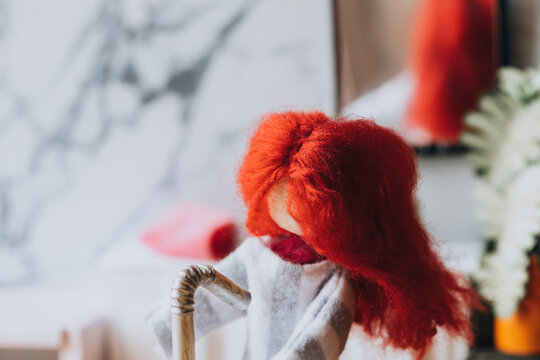 Red headed doll syanding in a bathroom at a sink. Room for copy.