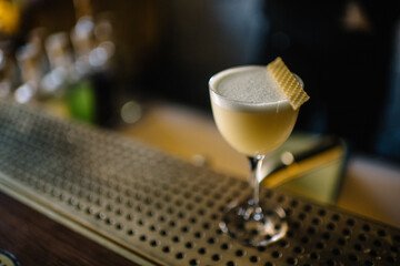 Glass of gin sour cocktail decorating with slice of honeycomb beeswax. 
