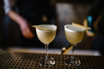 Two glasses of gin sour cocktail decorating with slice of honeycomb beeswax. 