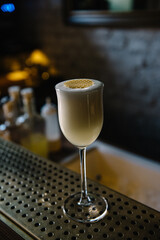 Glass of gin sour cocktail decorating with circles of honeycomb beeswax. 