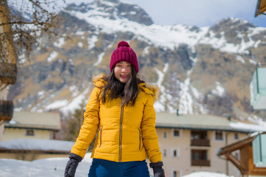winter lifestyle portrait of young happy and attractive Asian Chinese woman at beautiful snow mountains landscape enjoying Easter holidays in Swiss Alps smiling cheerful