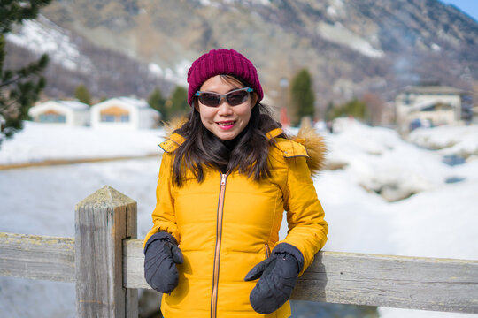 winter lifestyle portrait of young happy and attractive Asian Japanese woman at beautiful snow mountains landscape enjoying Easter holidays in Swiss Alps
