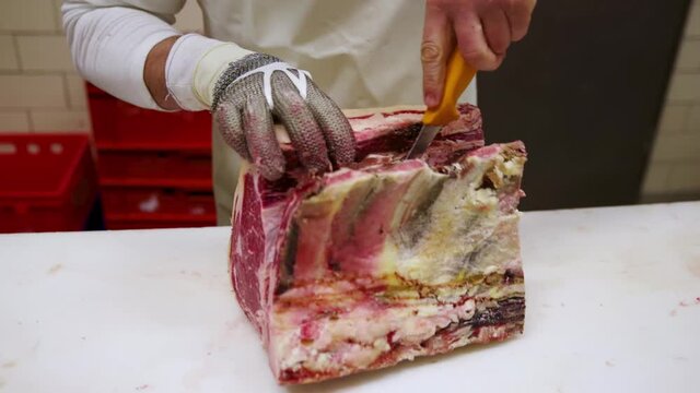Raw dry aged wagyu rib of beef steak cut up as close-up by a butcher on a table