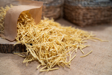 Homemade pasta on a natural colored wicker background and in front of a basket in the background. Turkish noodle
