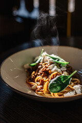 Carbonara pasta with feta cheese and basil leaves.