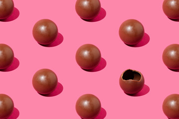 Creative chocolate balls pattern against pastel pink background. Minimal sweets backdrop.