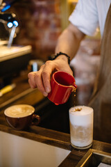 Pouring coffee into a cup of milk. Latte coffee.
