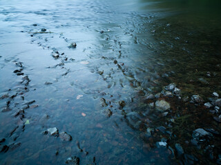 Abstract landscape with random pattern, shallow water flow over gravel creating miniature cascaes