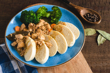 Veal stew with steamed yeast dumplings served with broccoli