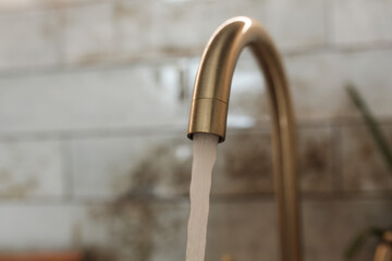 Tap with flowing water. Faucet in the kitchen.